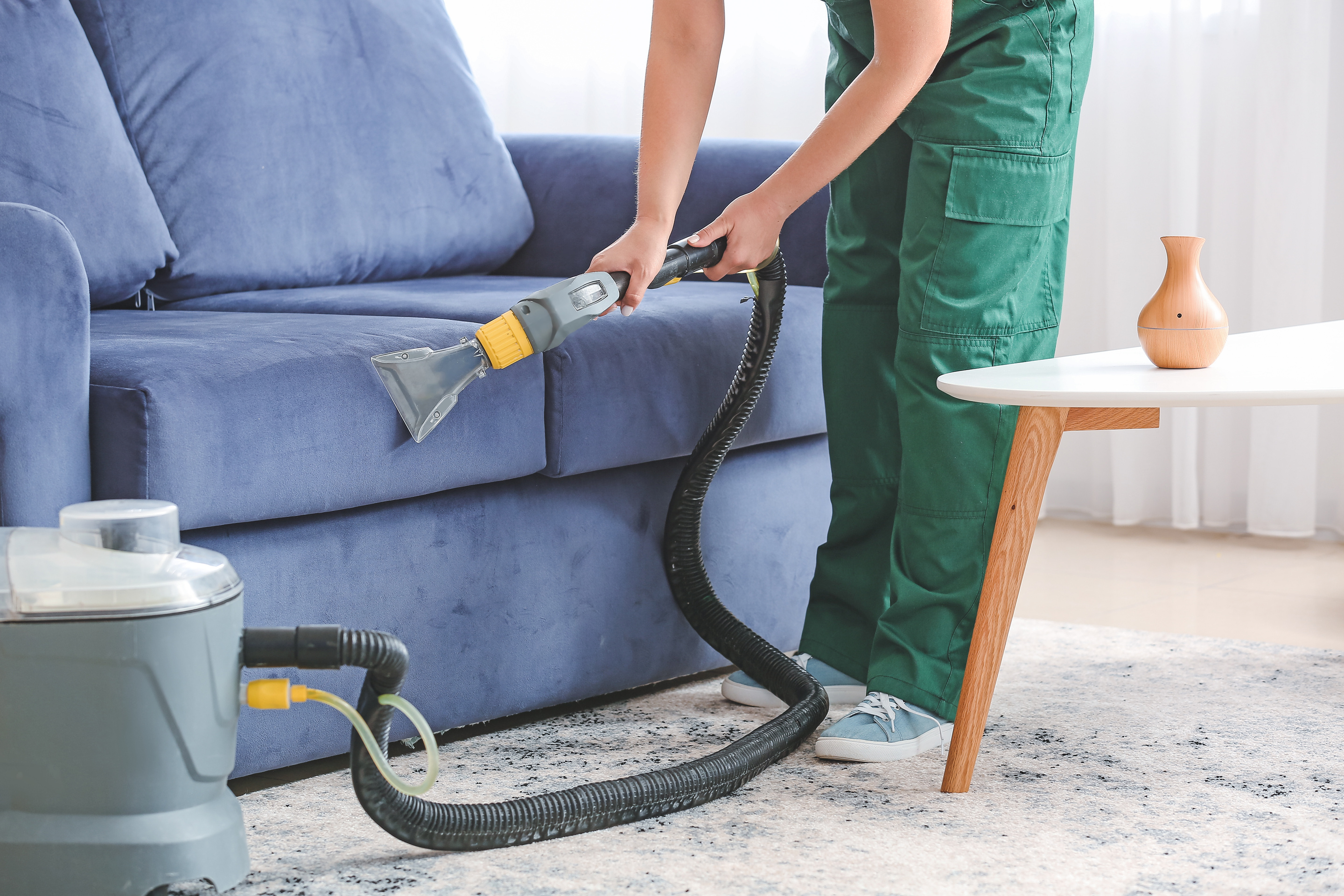 Cleaner Removing Dirt from Sofa